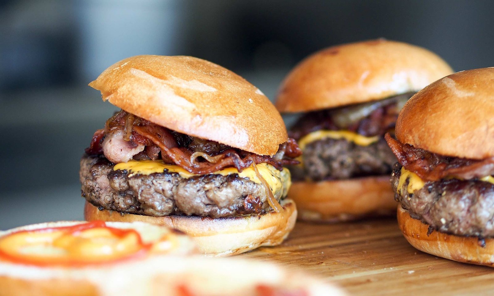 3 burgers on a board